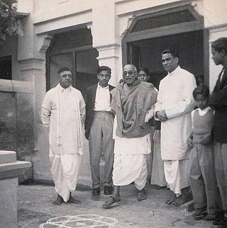 C. Rajagopalachari standing among a small group of colleagues outside a house.