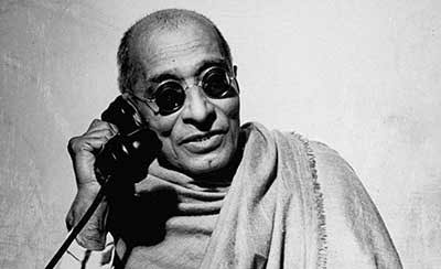 C. Rajagopalachari holding a telephone handset to his ear.